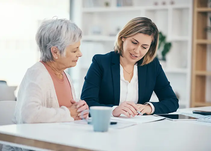 two women looking at papers at a table